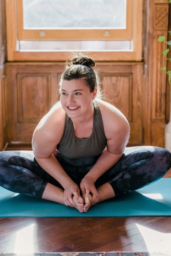 Woman stretching on yoga mat as a productive thing to do at home.