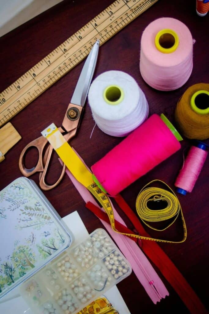 Sewing materials consisting of scissors, threads, and ruler.