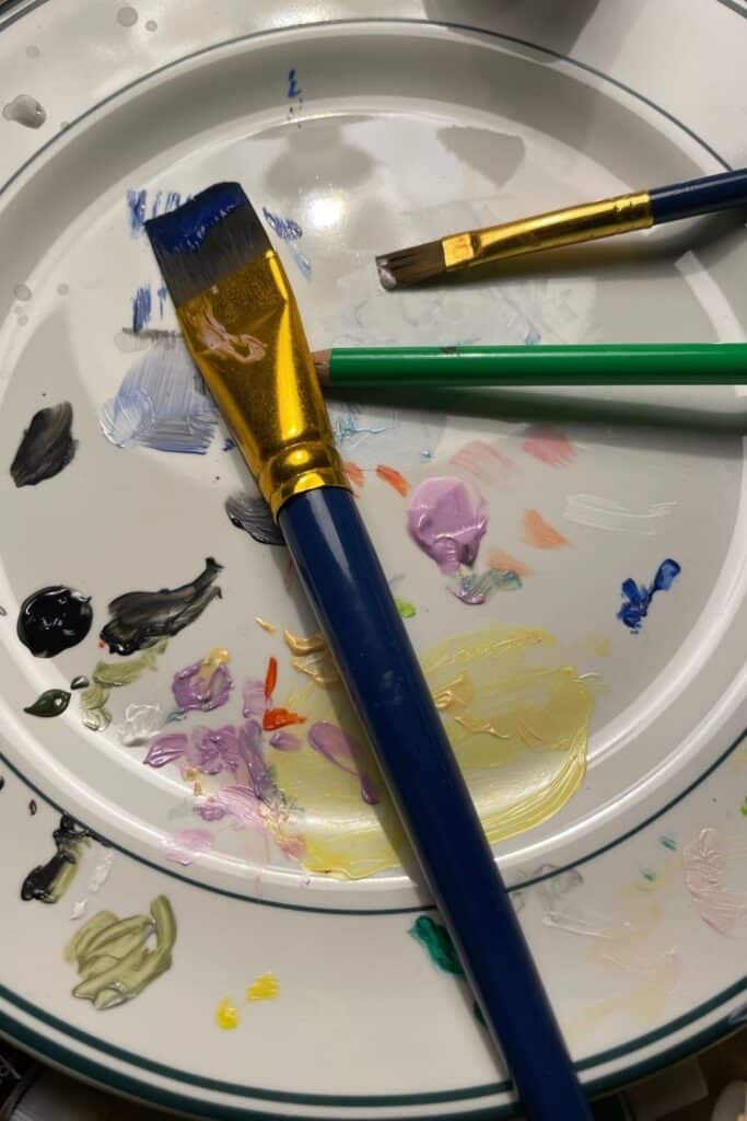Plate being used as paint brush palette
